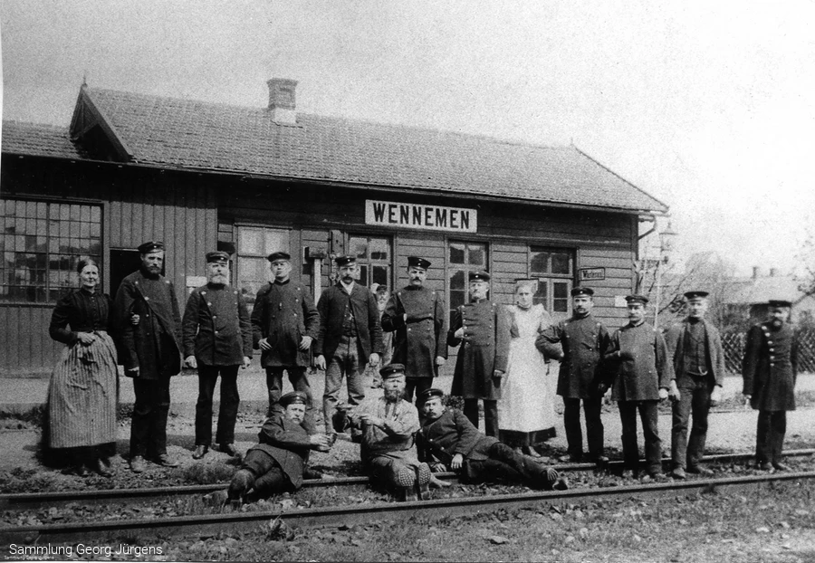 Das erste Bahnhofsgeb&auml;ude von Wennemen um 1873. Der Zugverkehr scheint noch selten zu sein, sonst h&auml;tte man sich nicht zum Umtrunk und Foto im Gleis versammeln k&ouml;nnen